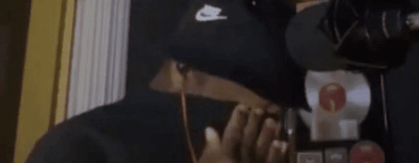 Person covering face in recording studio.